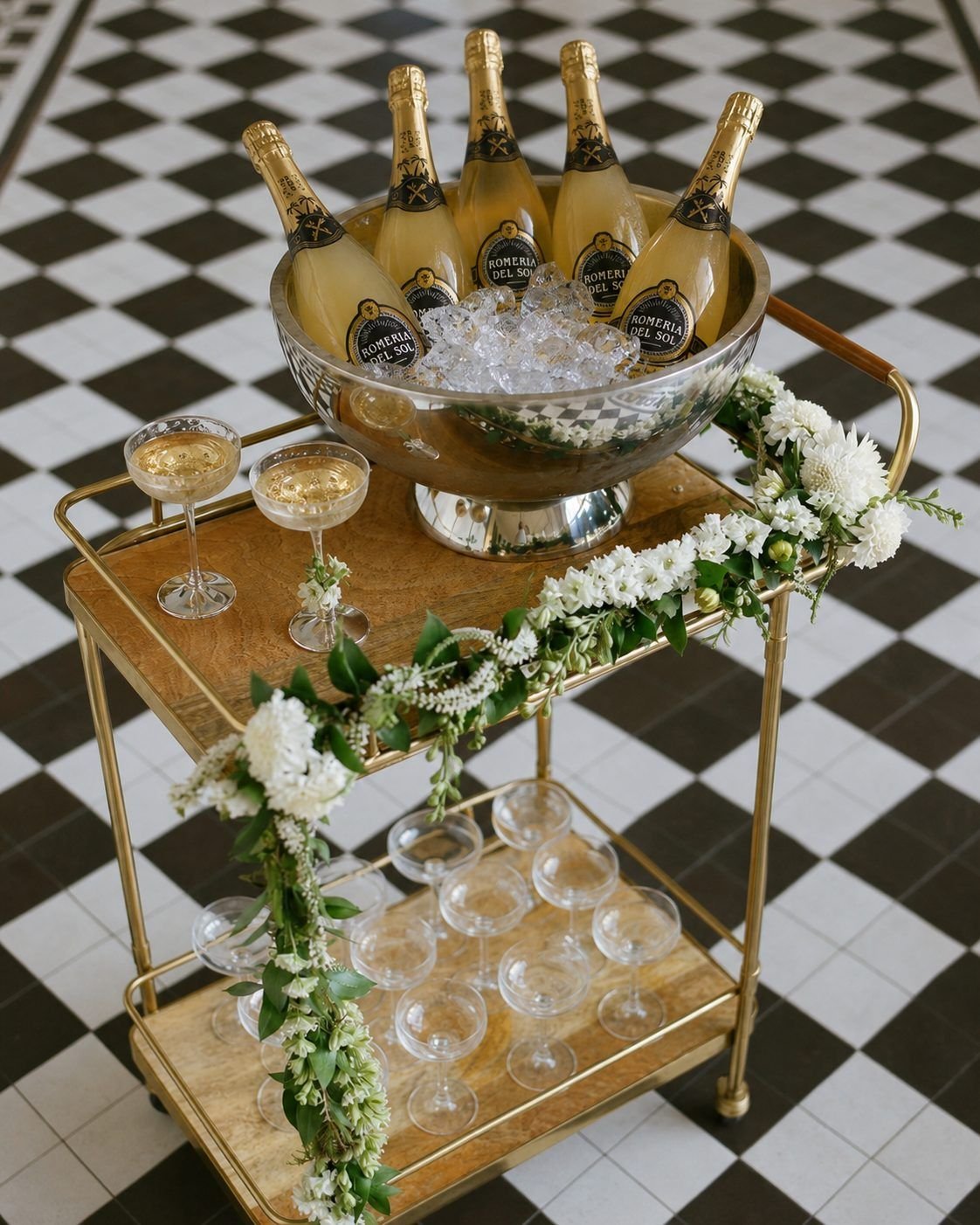 Bar cart doré avec vasque de bouteilles Romeria del Sol sur glace et coupes